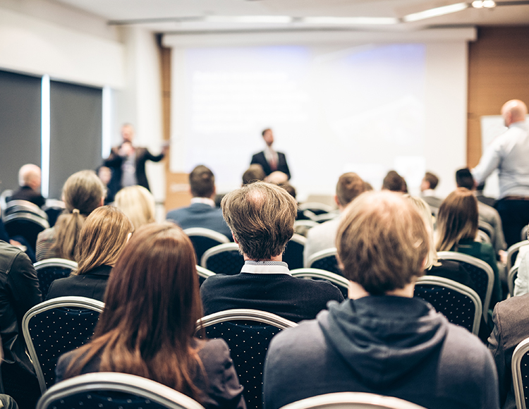 a man standing in front of a group of people in a room