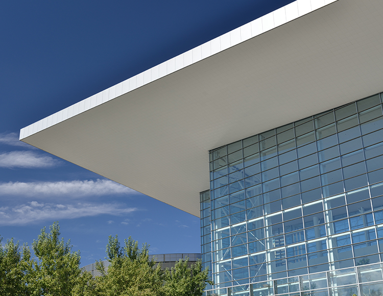 a building with glass walls and trees
