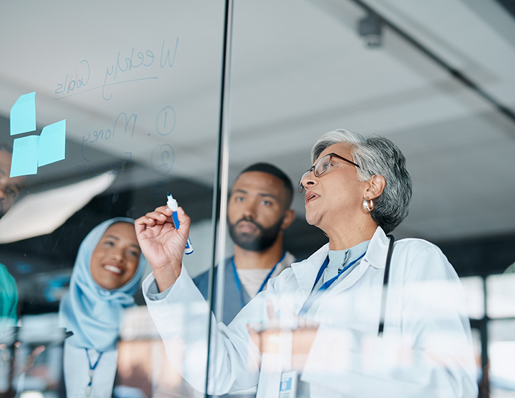 a group of people writing on a glass wall