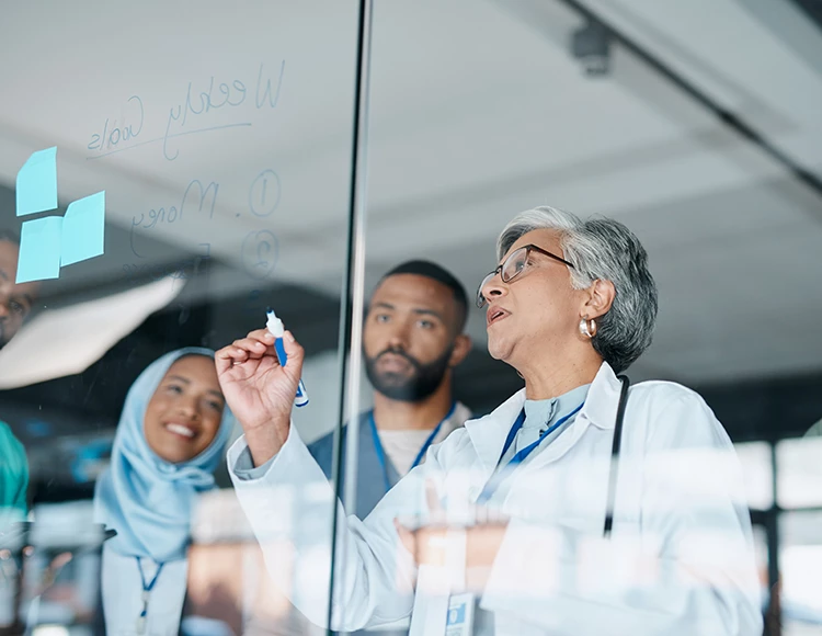 a group of people writing on a glass wall