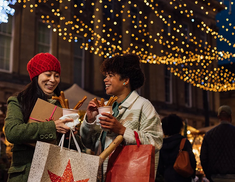 two women holding food and bags
