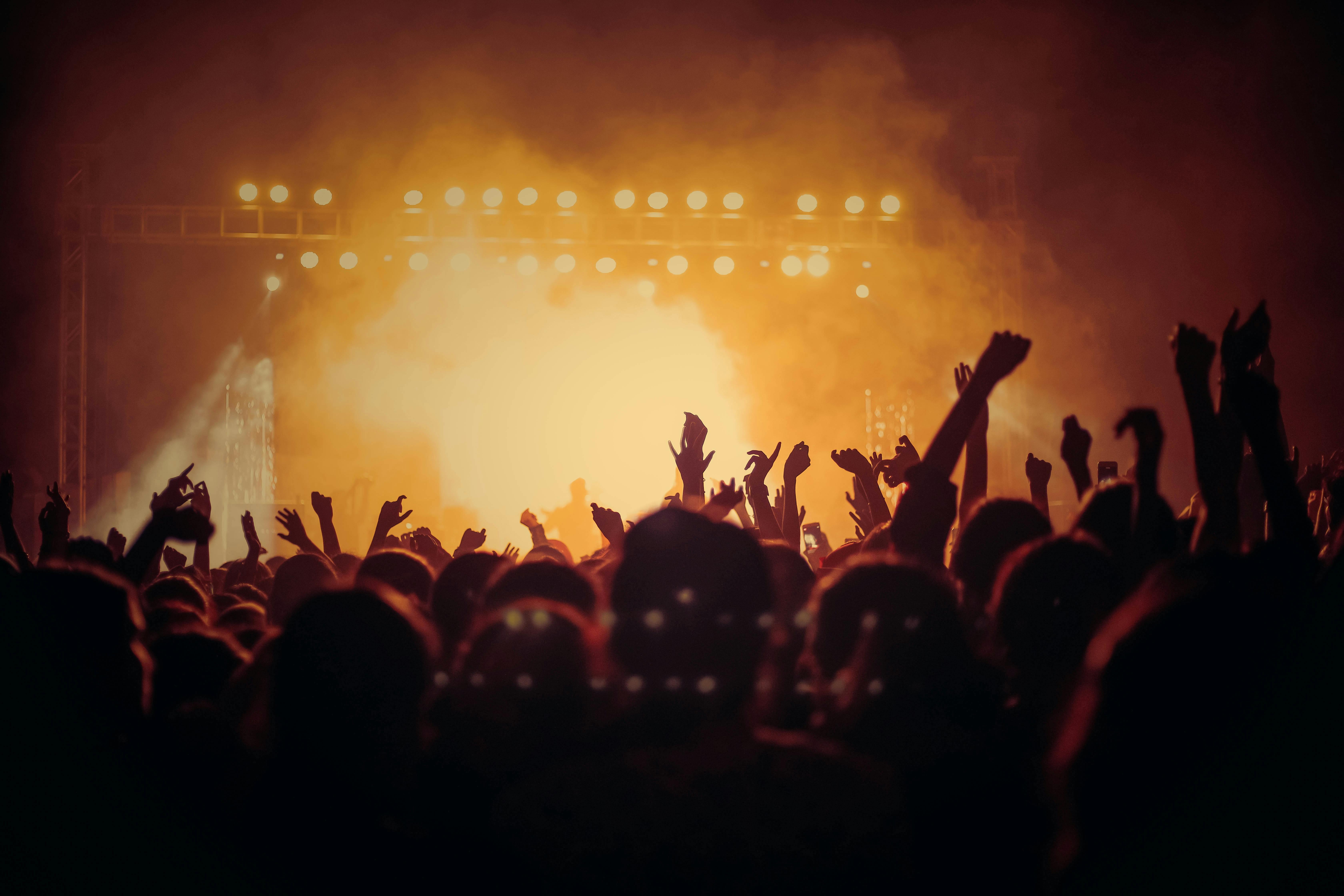 a crowd of people with their hands up in the air
