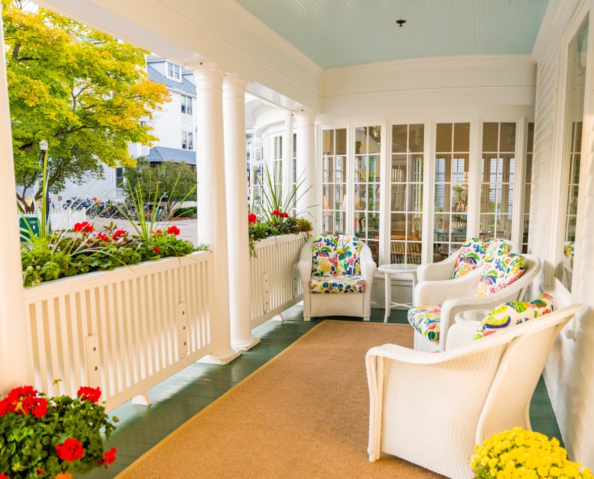 a porch with chairs and flowers