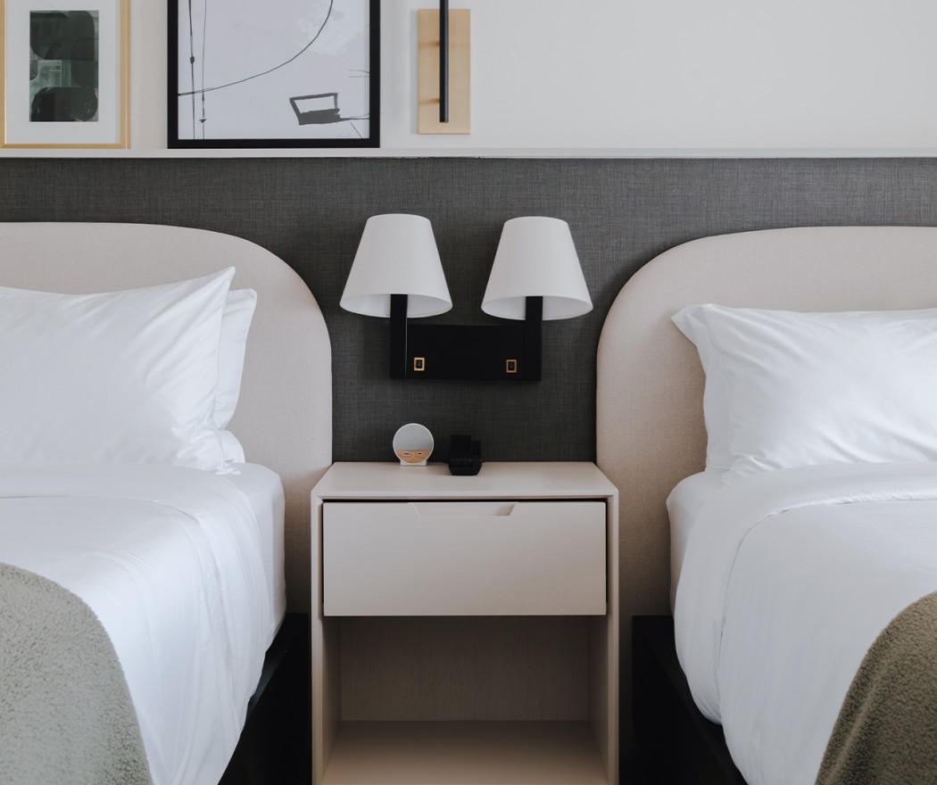 a bed with white pillows and a nightstand