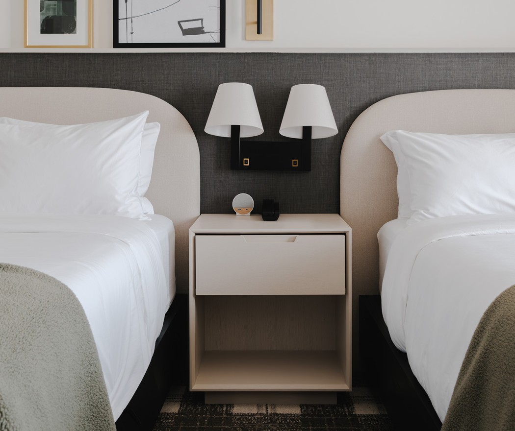 a bed with white sheets and a nightstand