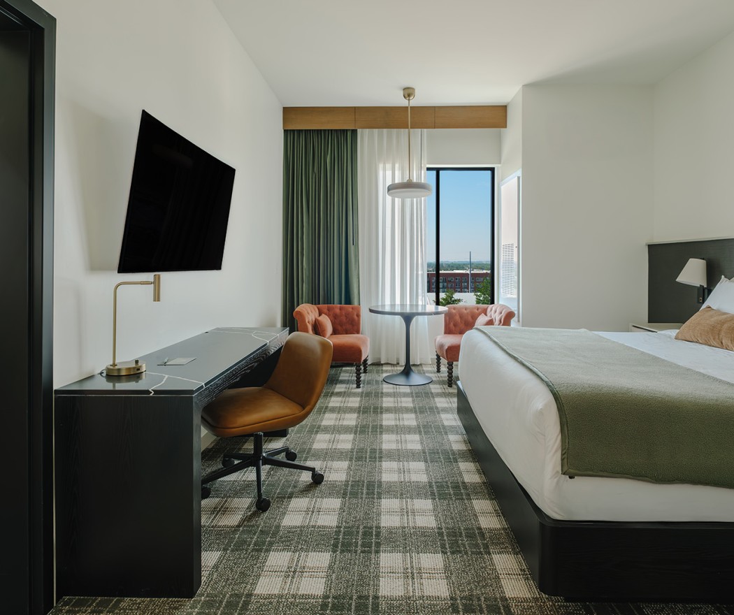 a room with a bed and a desk and chairs
