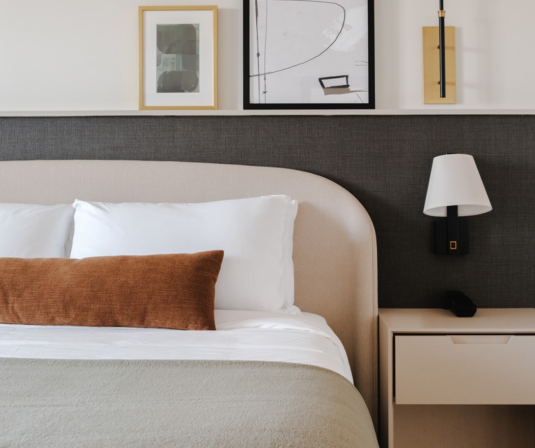 a bed with a lamp and a picture above it