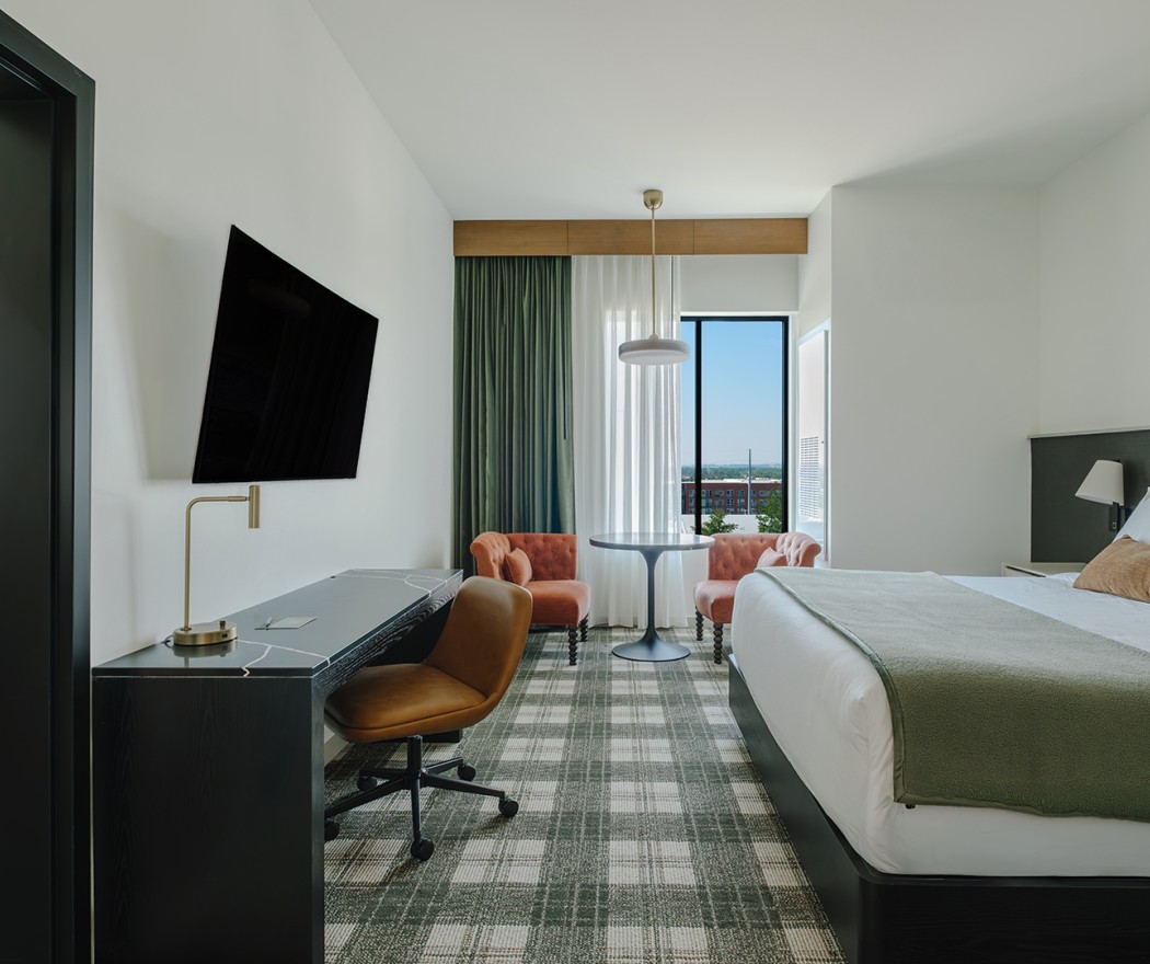 a room with a bed and a desk and chairs