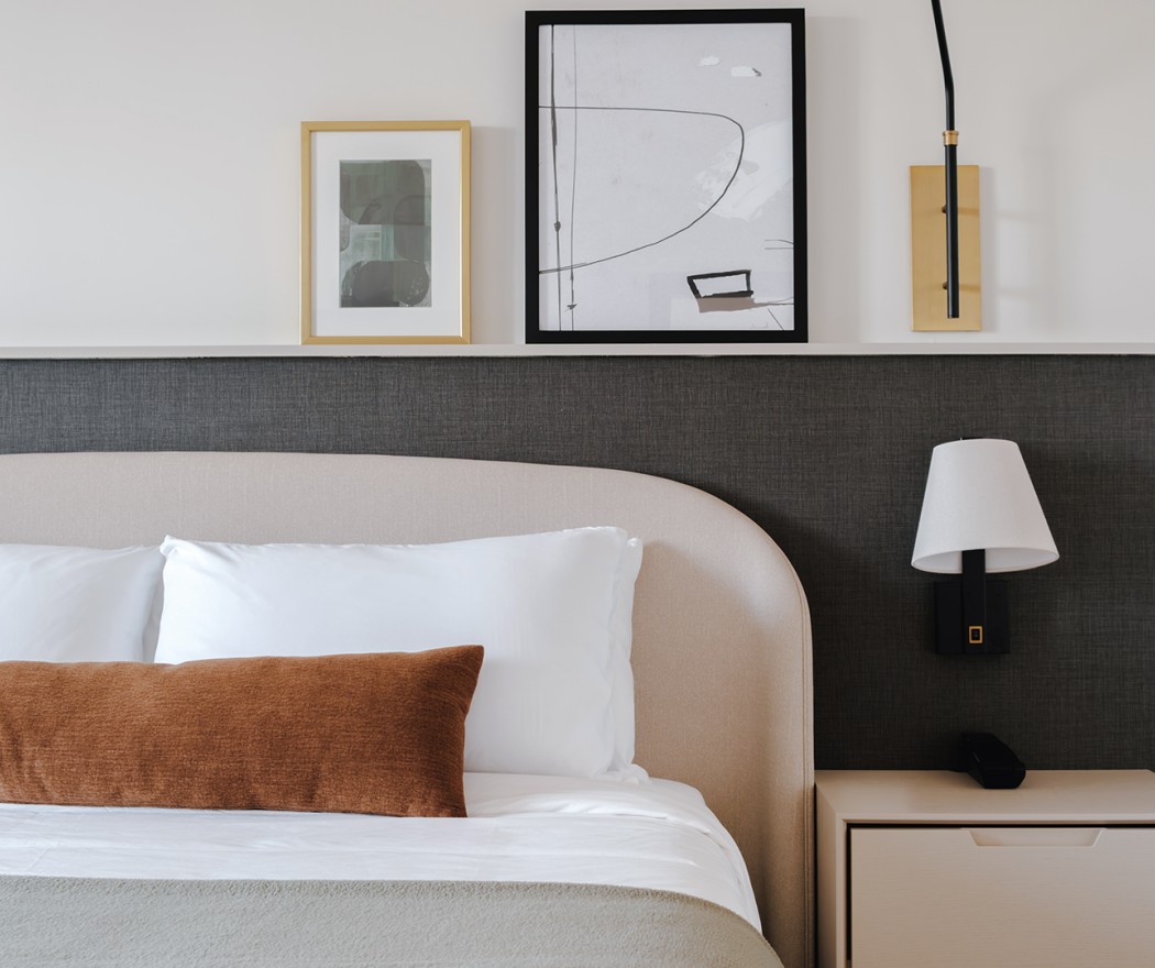 a bed with a lamp and a picture above it
