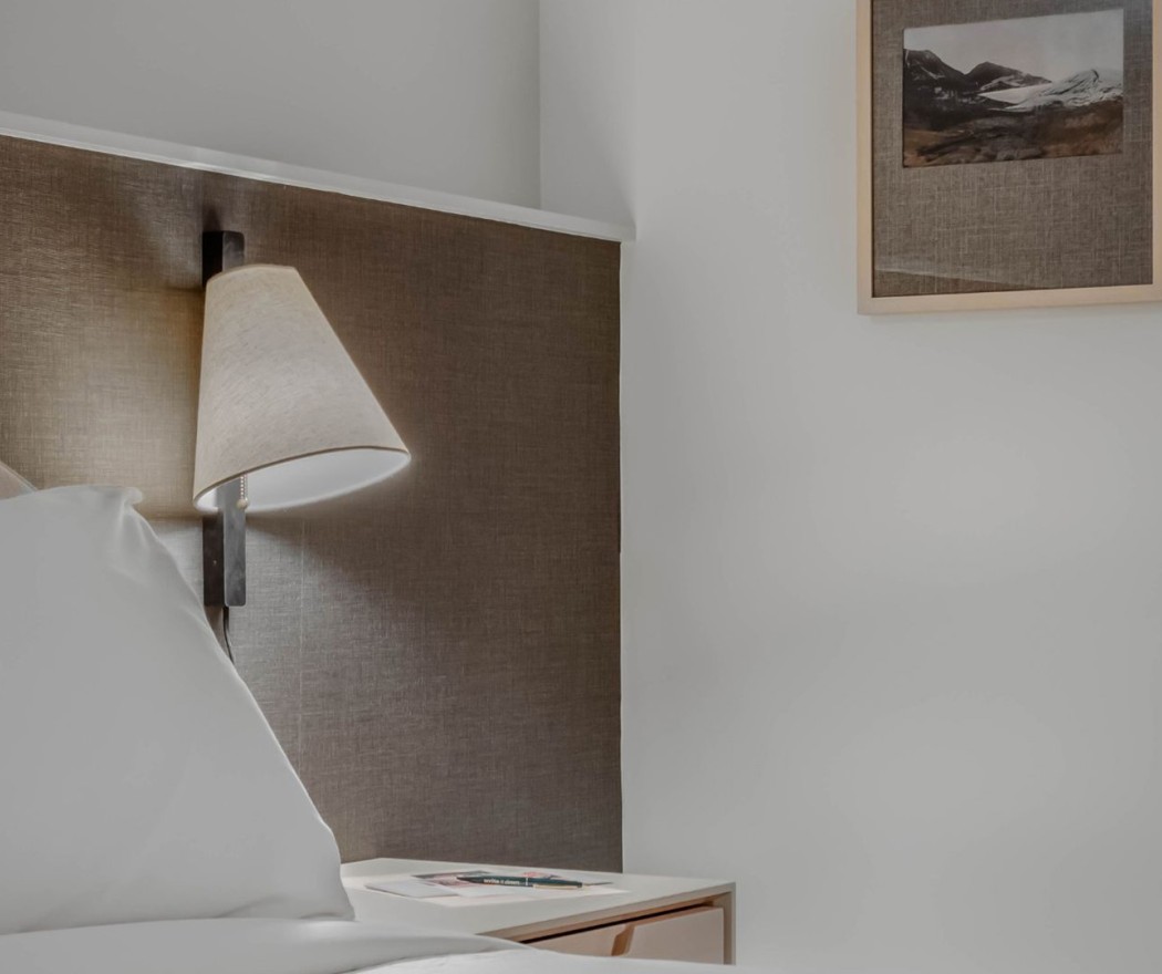 a lamp on a table next to a bed