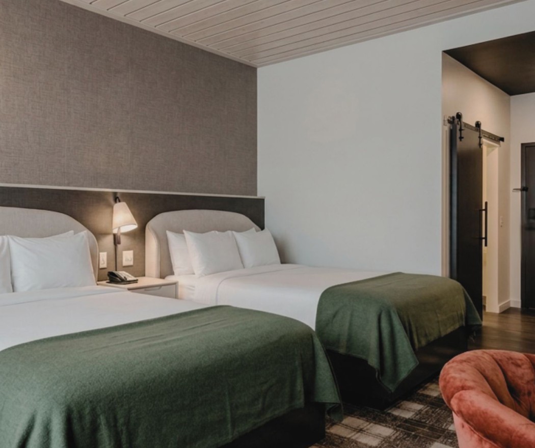 a room with two beds and a red chair