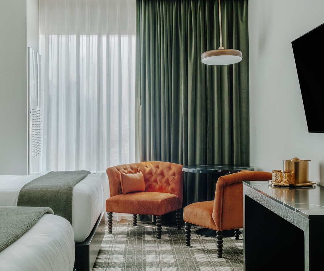 a room with a bed and chairs