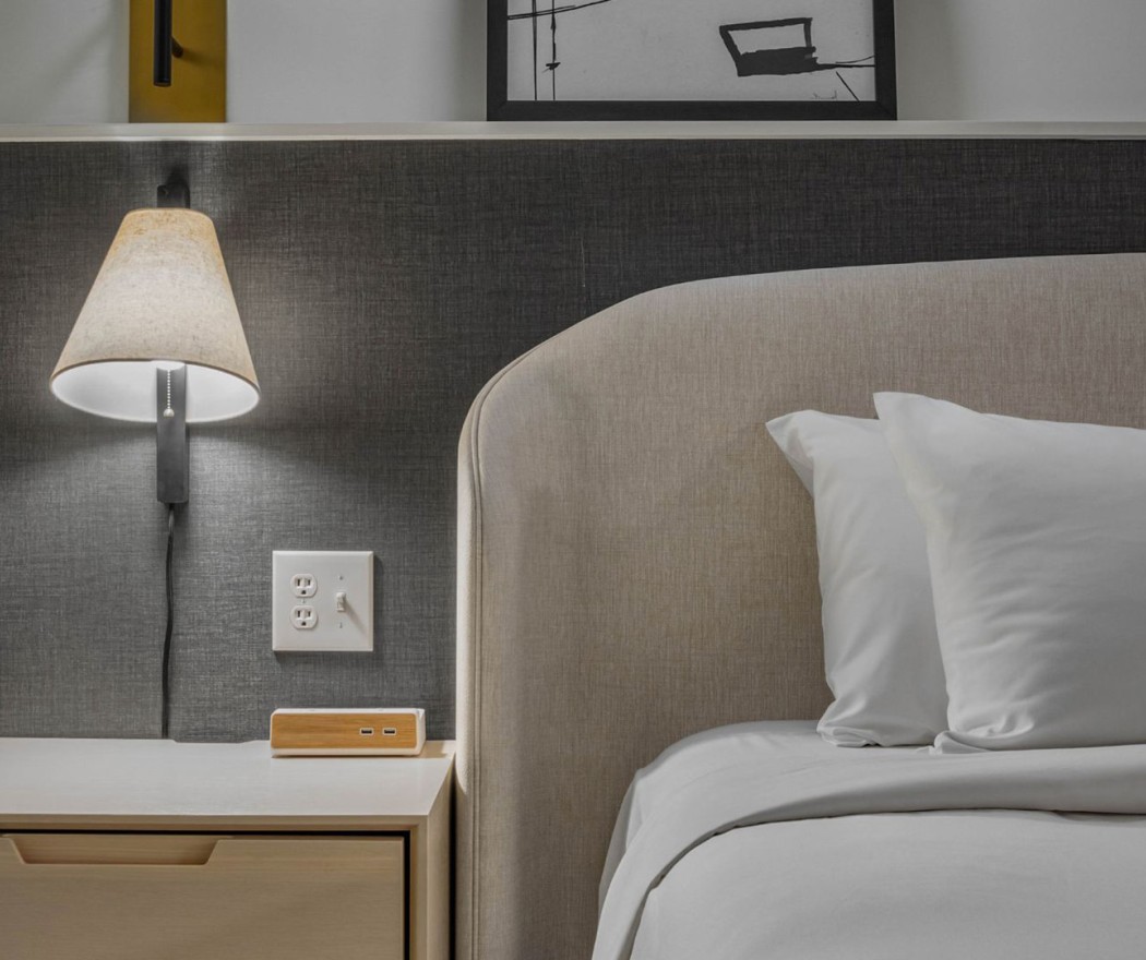 a bed with a lamp and a nightstand