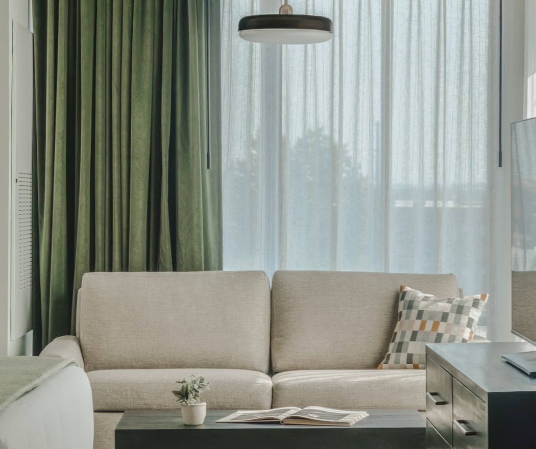 a couch in a room with green curtains