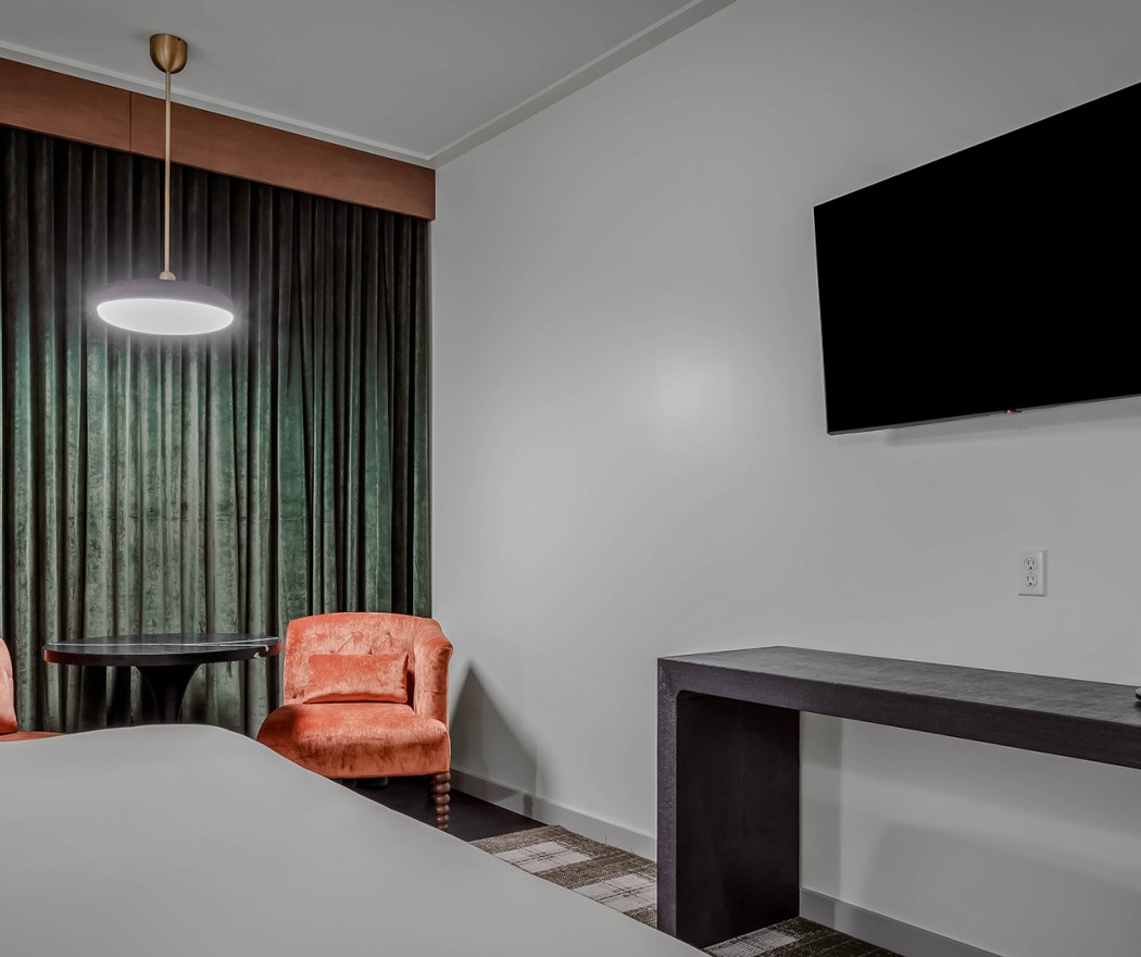 a room with a table and chair and a tv on the wall