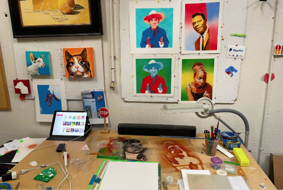 a desk with a laptop and pictures on it