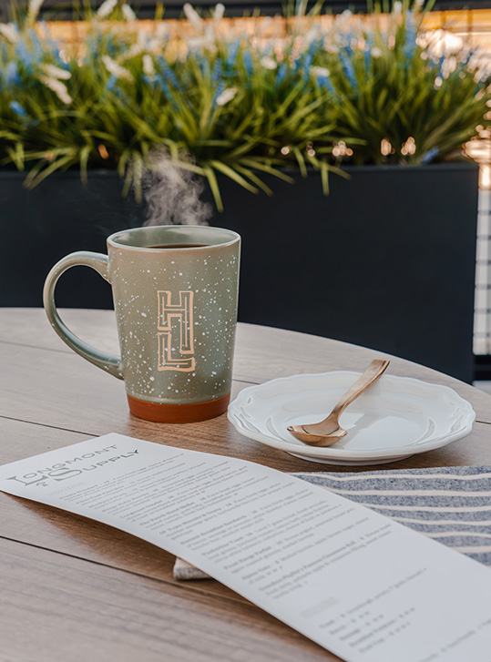 a cup of coffee with a spoon and plate on a table