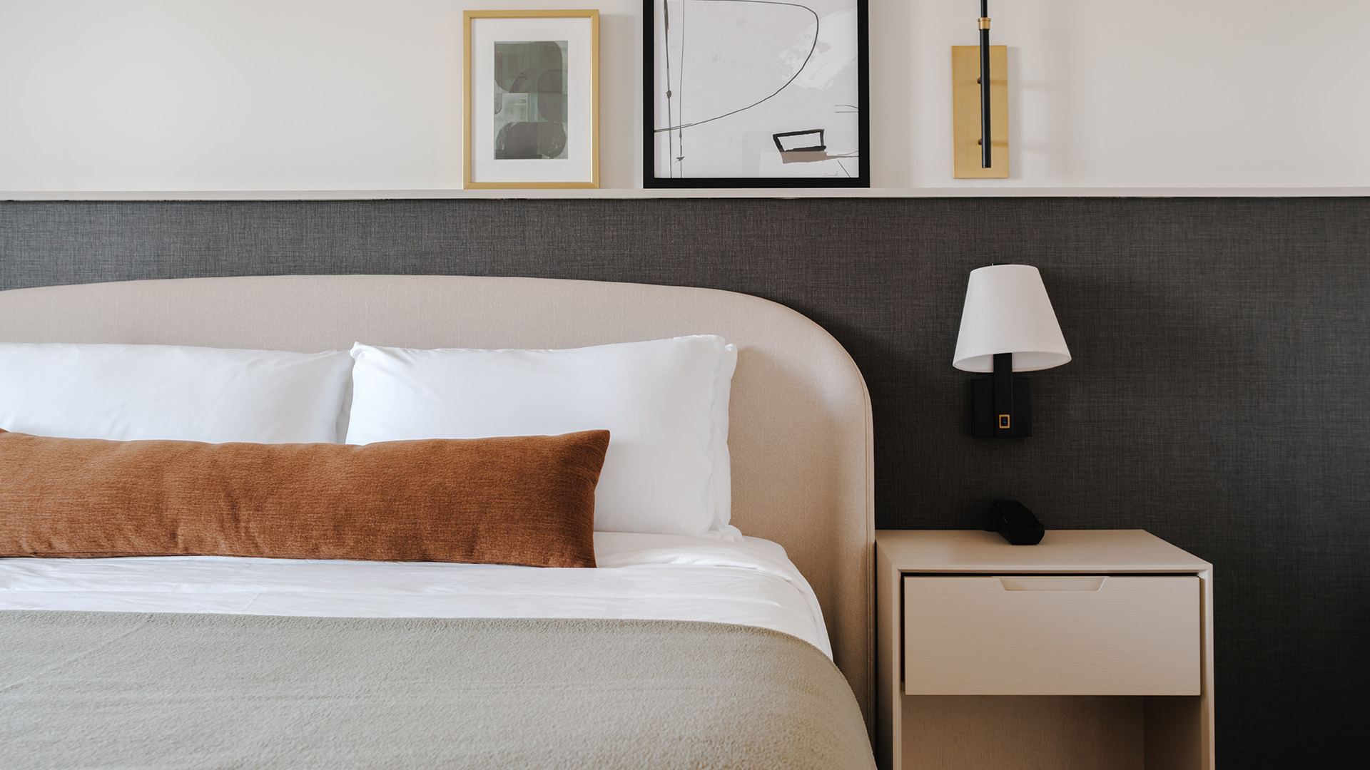 a bed with a lamp and a picture above it