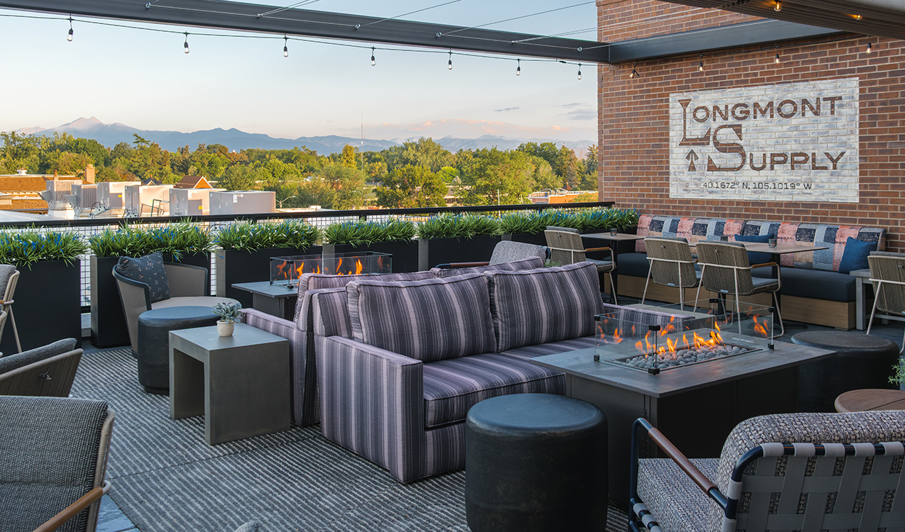 a patio with a fire pit and chairs