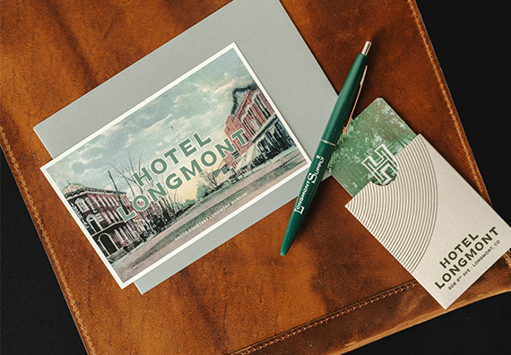 a pen and postcard on a leather surface