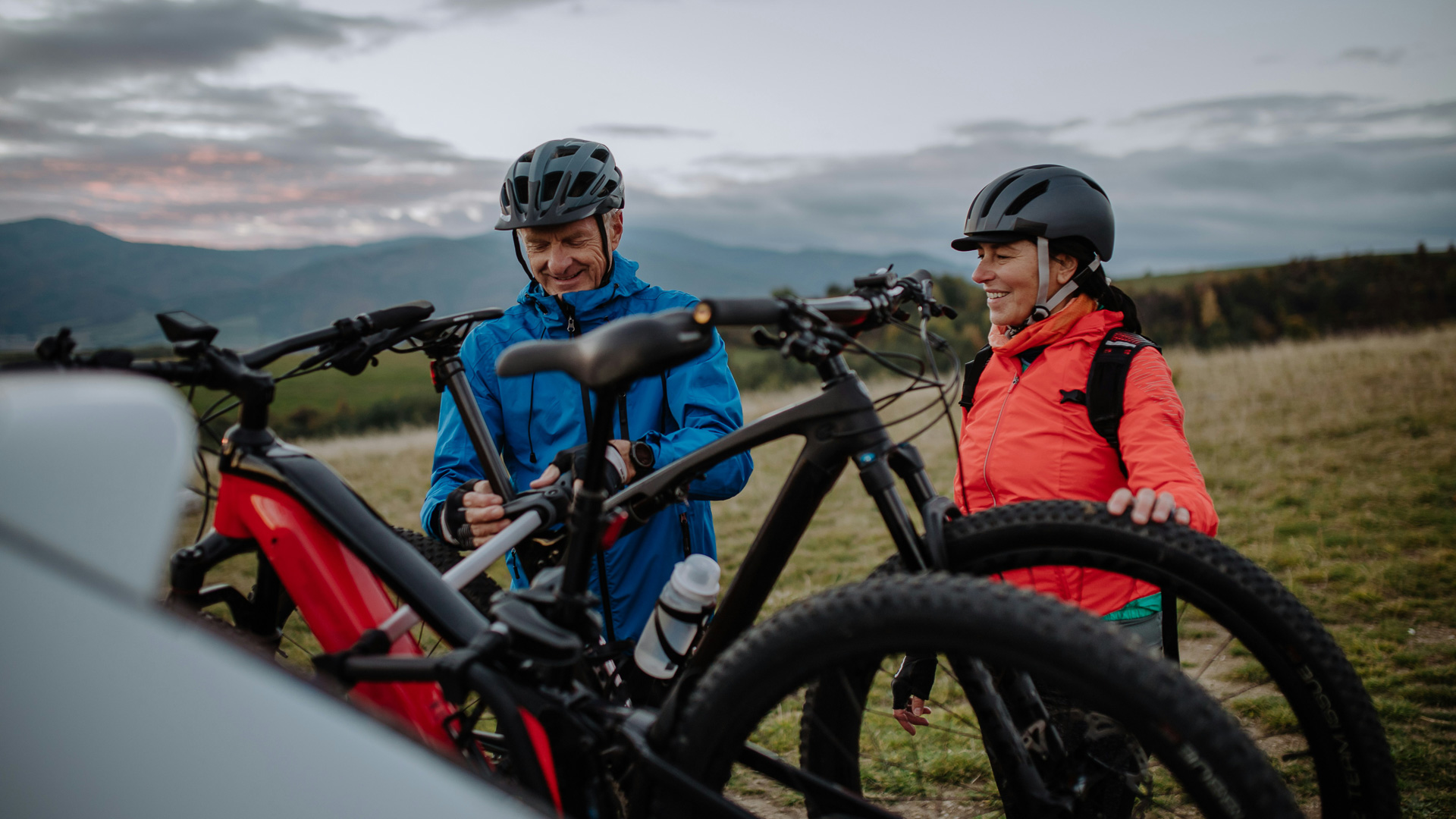 a man and woman with helmets and bikes