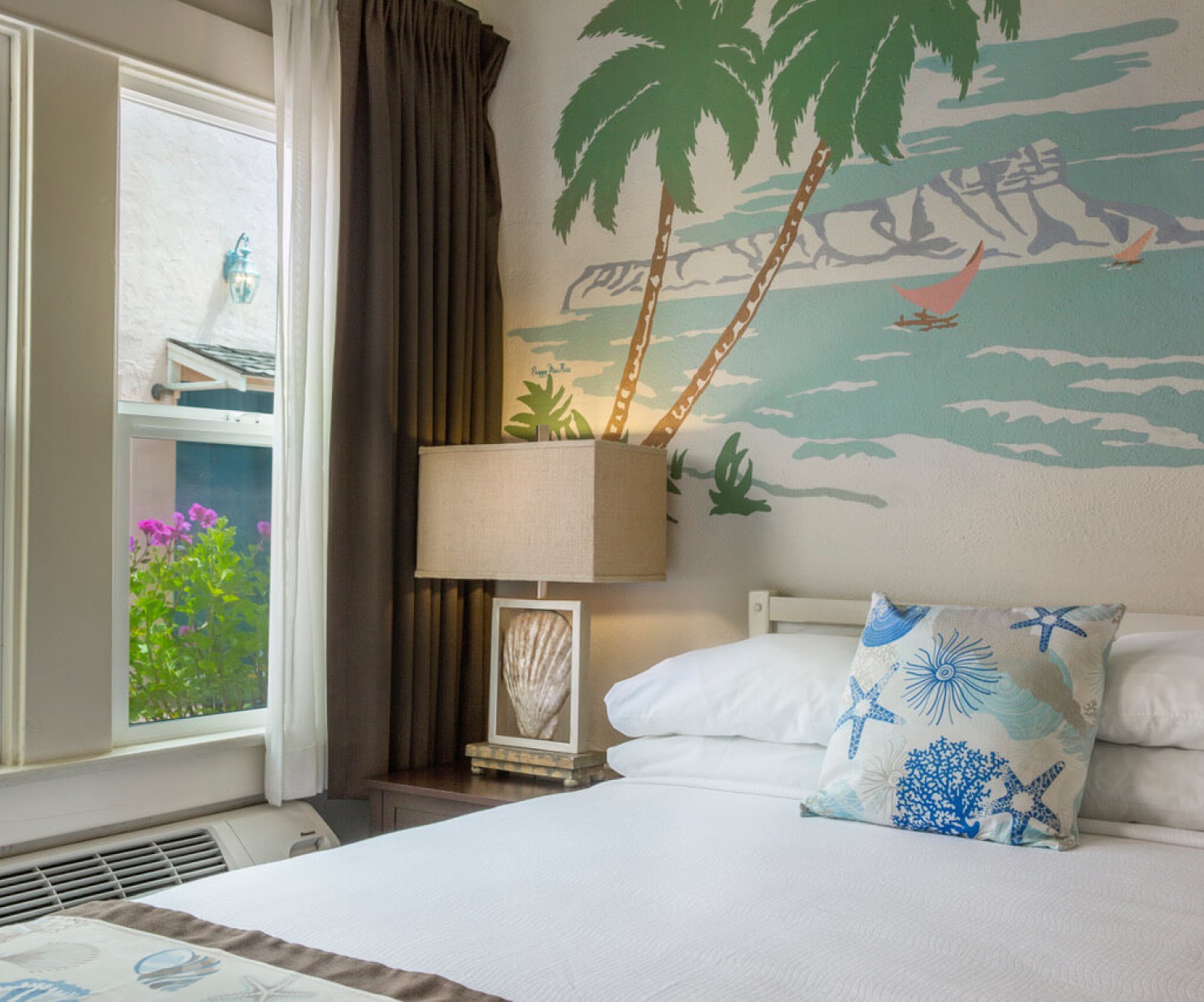a bed with a lamp and a painting on the wall