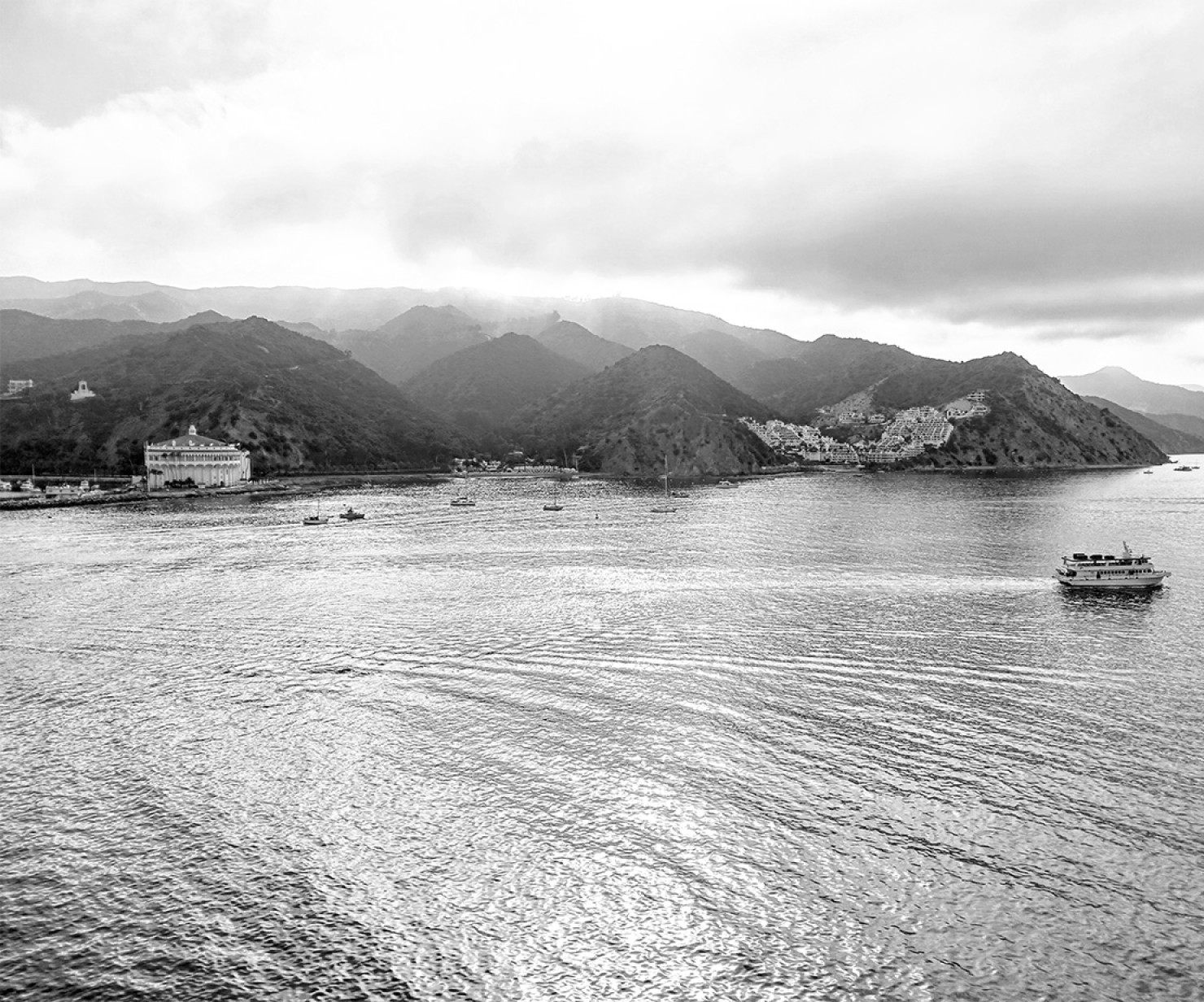 a body of water with boats and mountains in the background