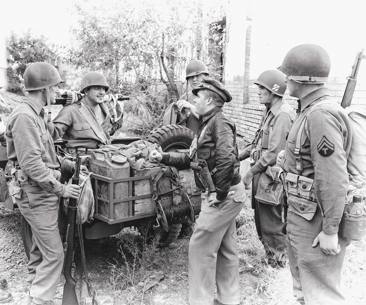 a group of soldiers standing around a vehicle