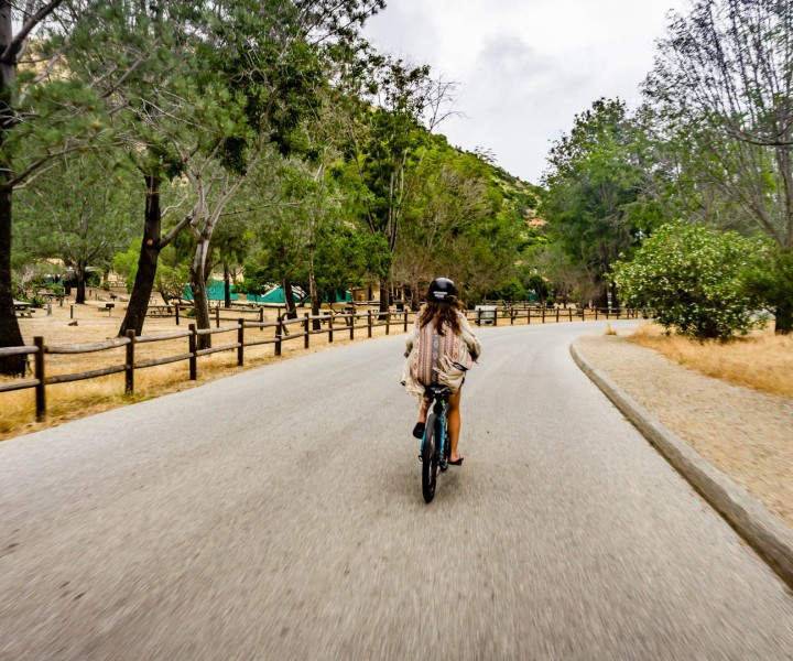 a woman riding a bicycle down a road
