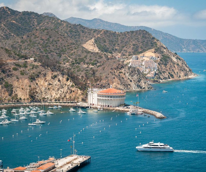 a large white building on a rocky island with boats in the water