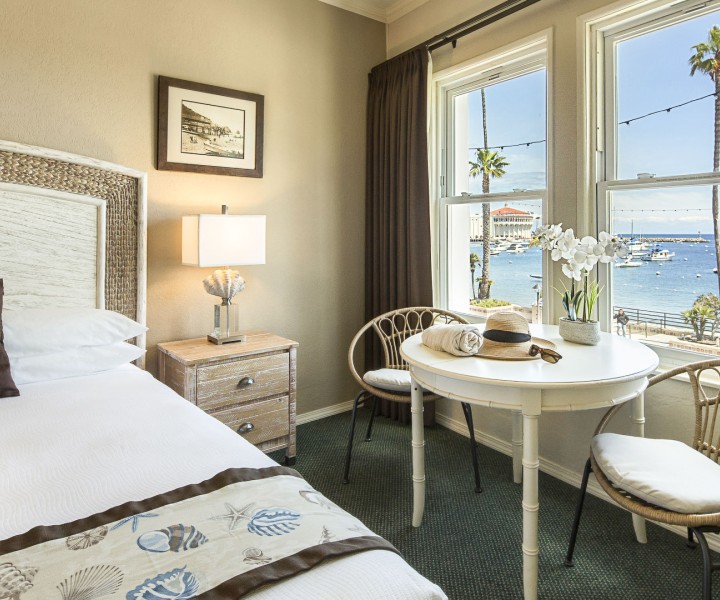 a room with a table and chairs and a bed and a table with a hat
