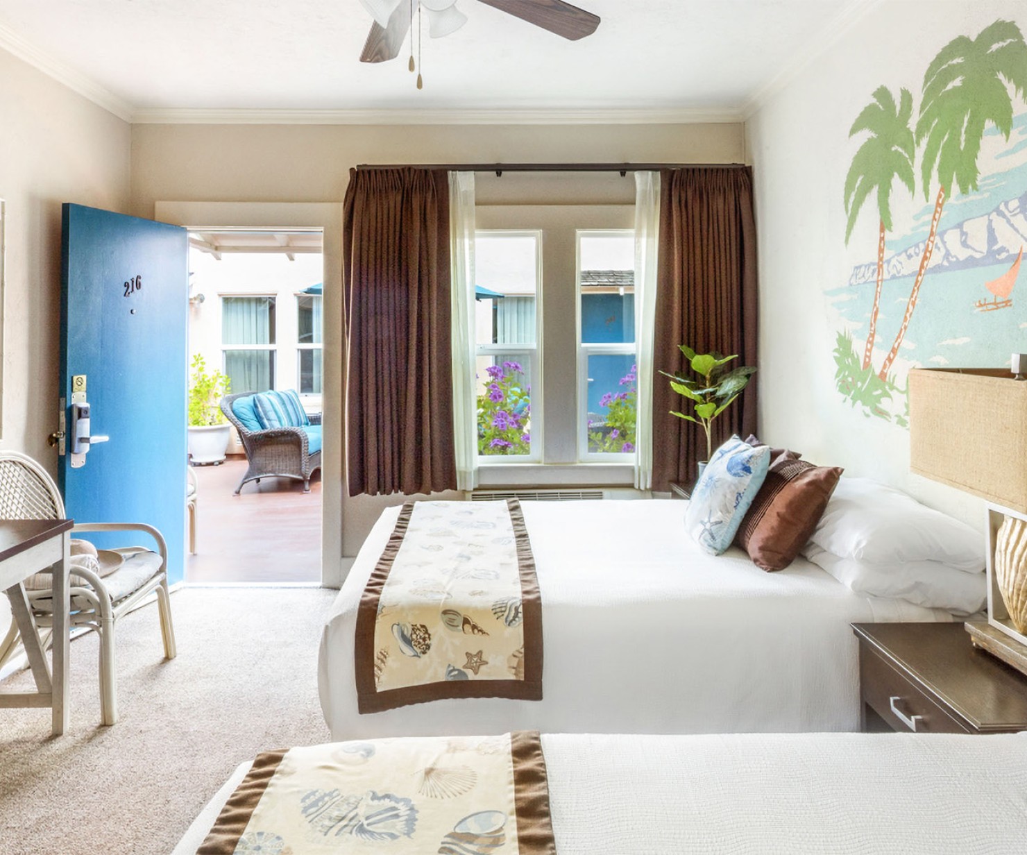 a room with two beds and a fan