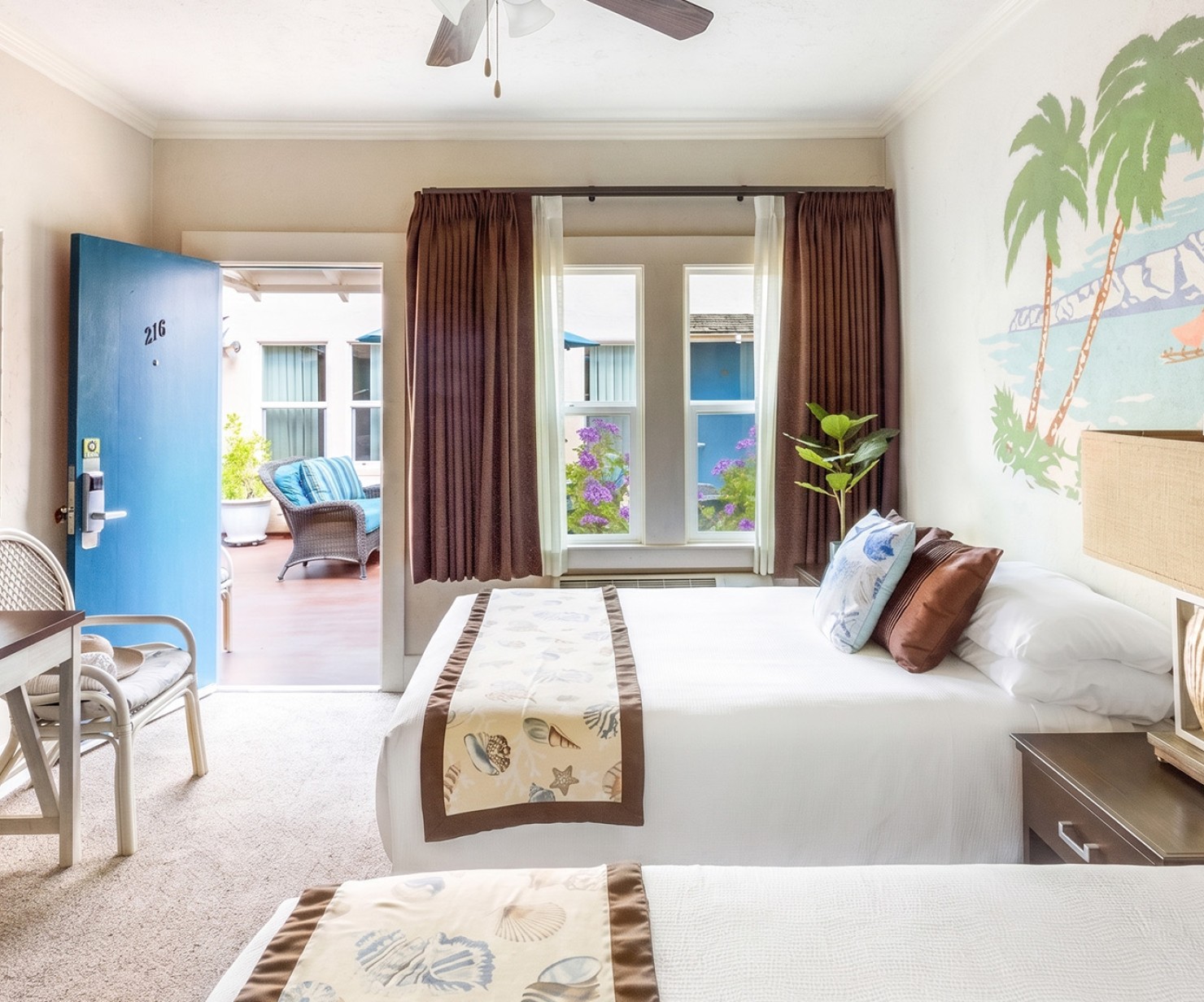 a room with two beds and a fan