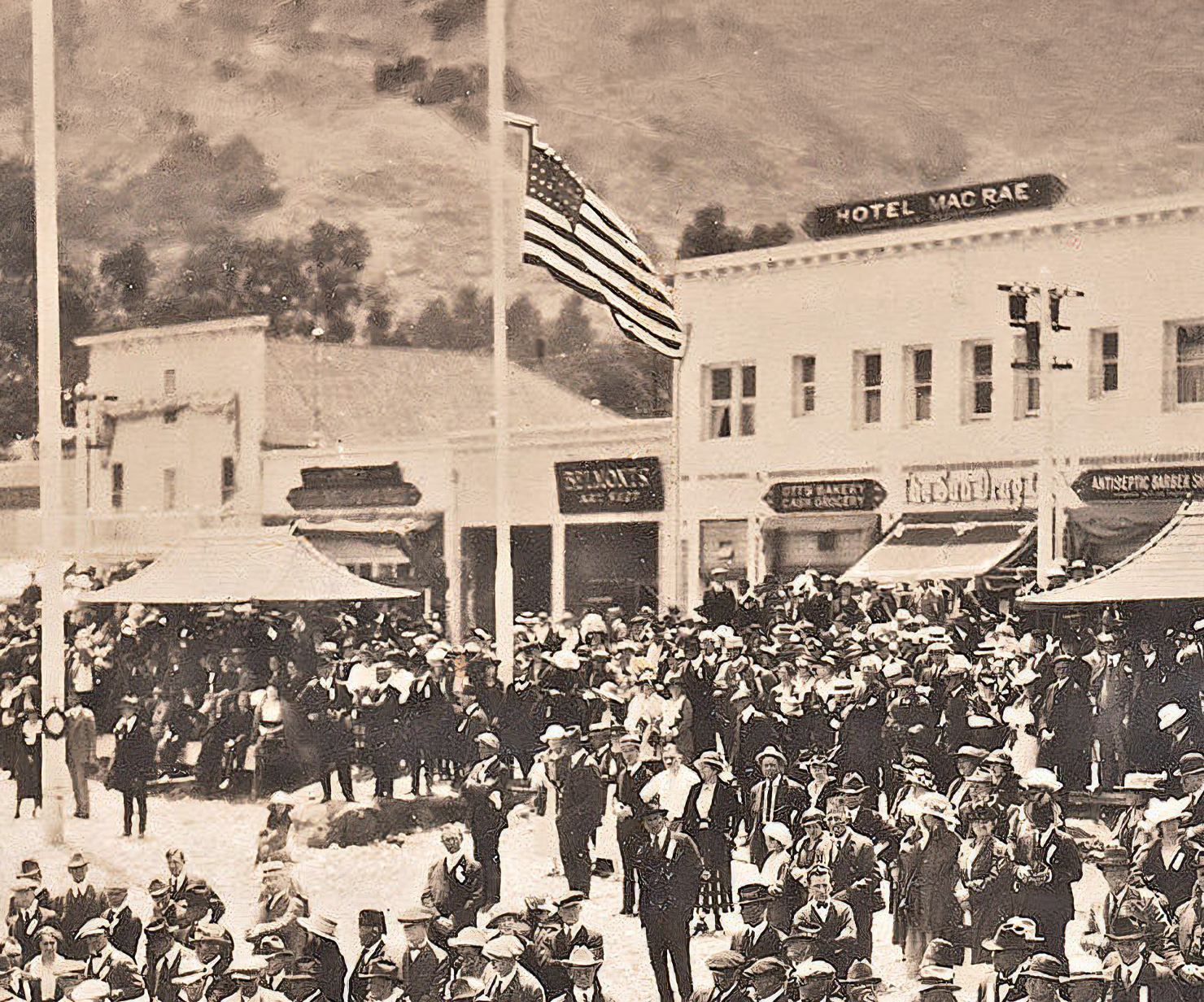 a large crowd of people in front of a flagpole