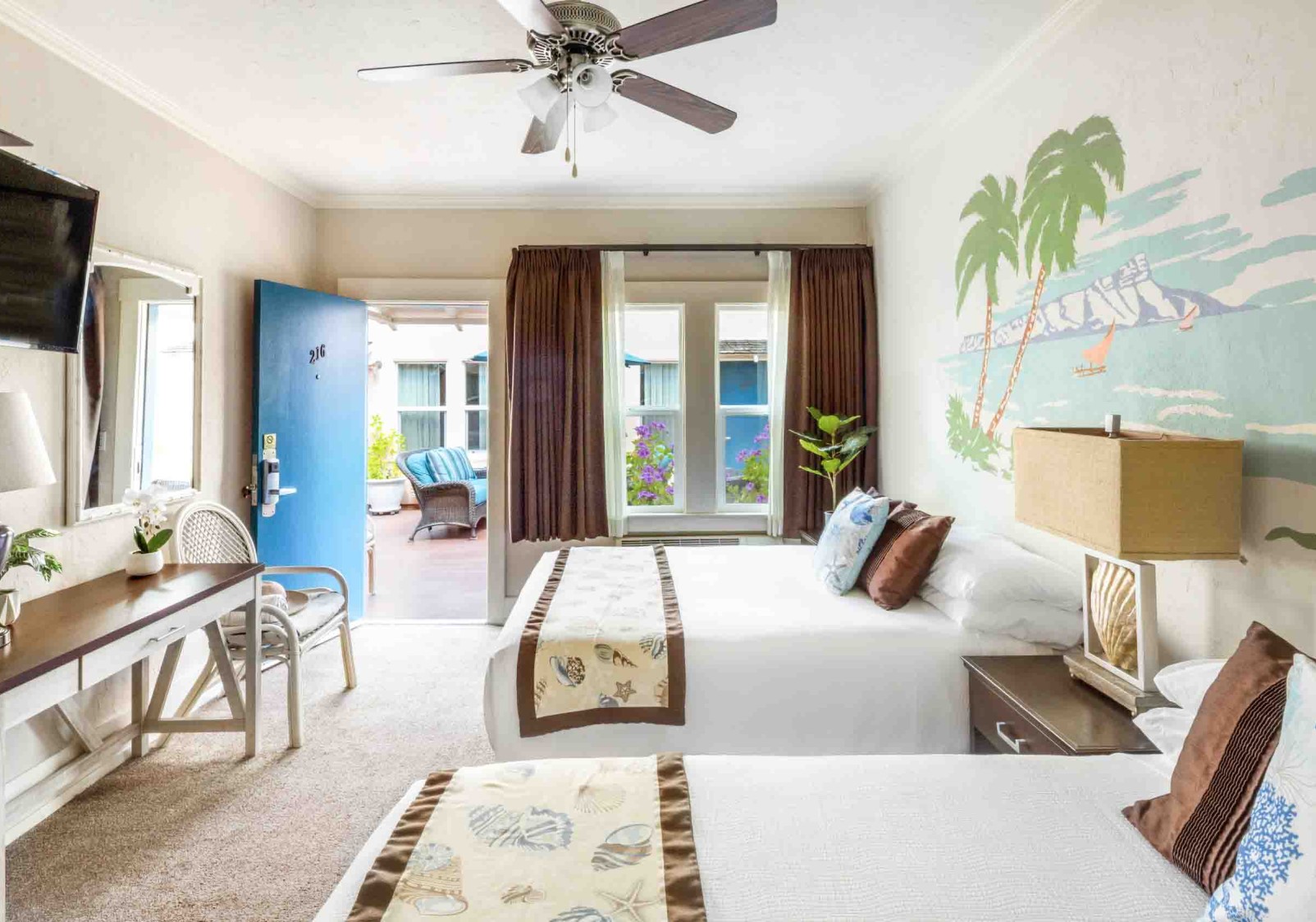 a room with two beds and a fan