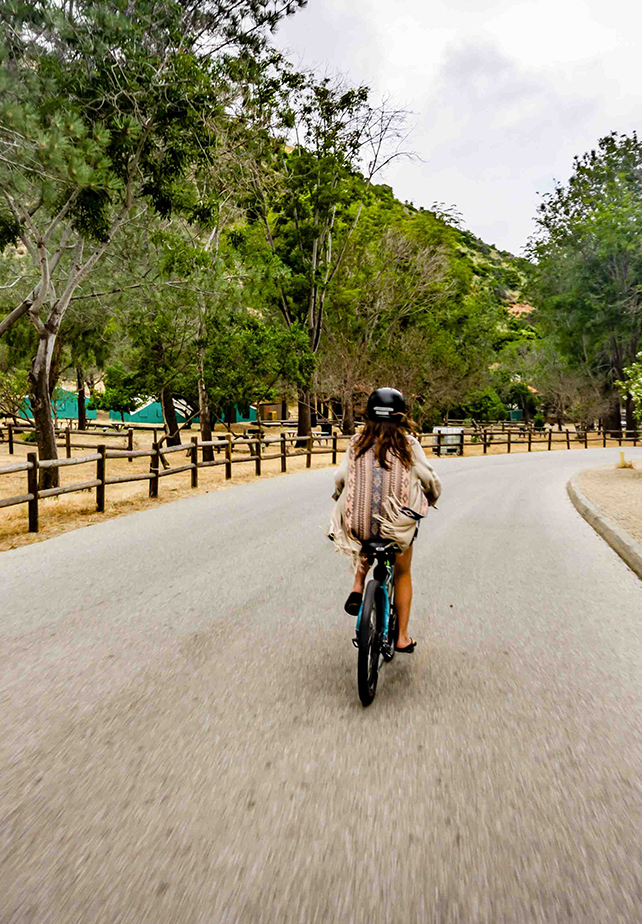 a woman riding a bicycle down a road