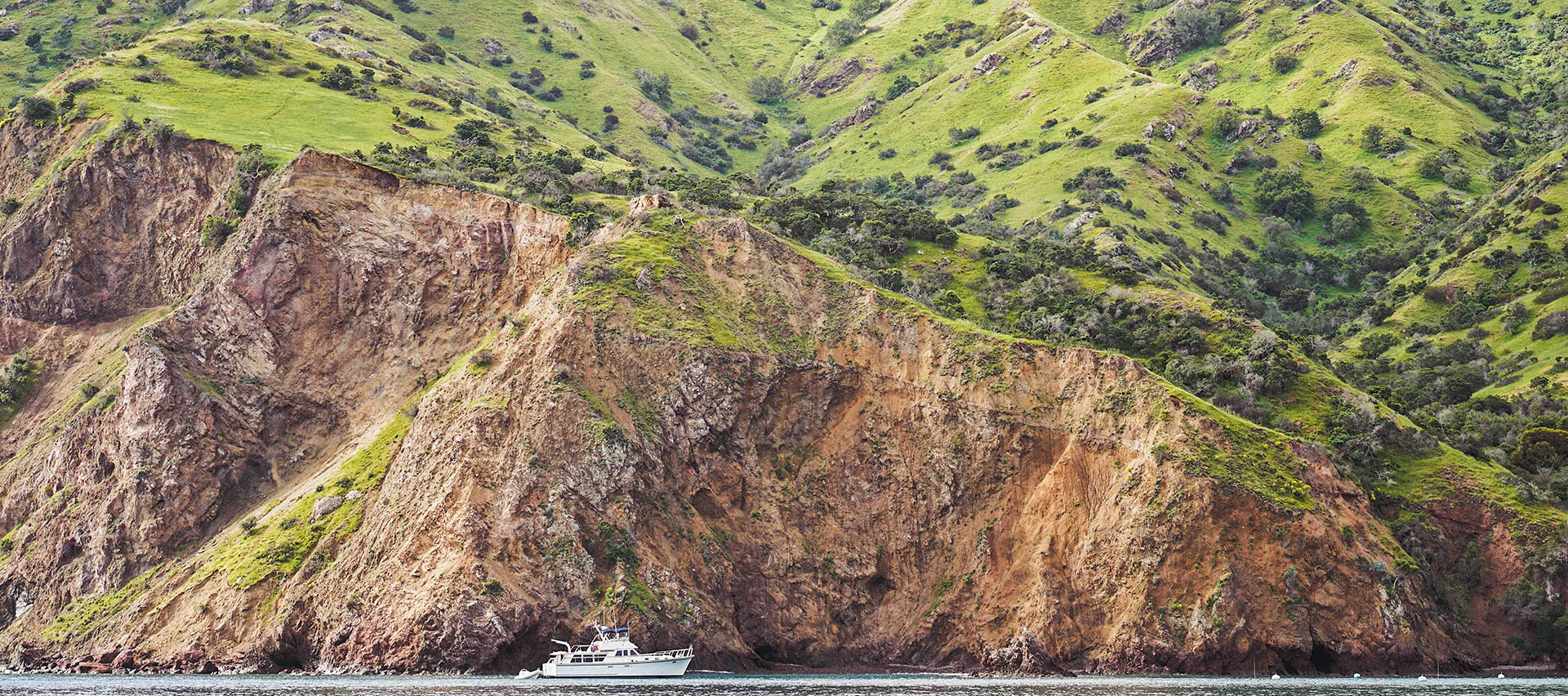 a boat on the water near a cliff