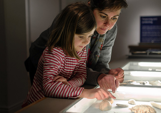 a woman and a girl looking at a display