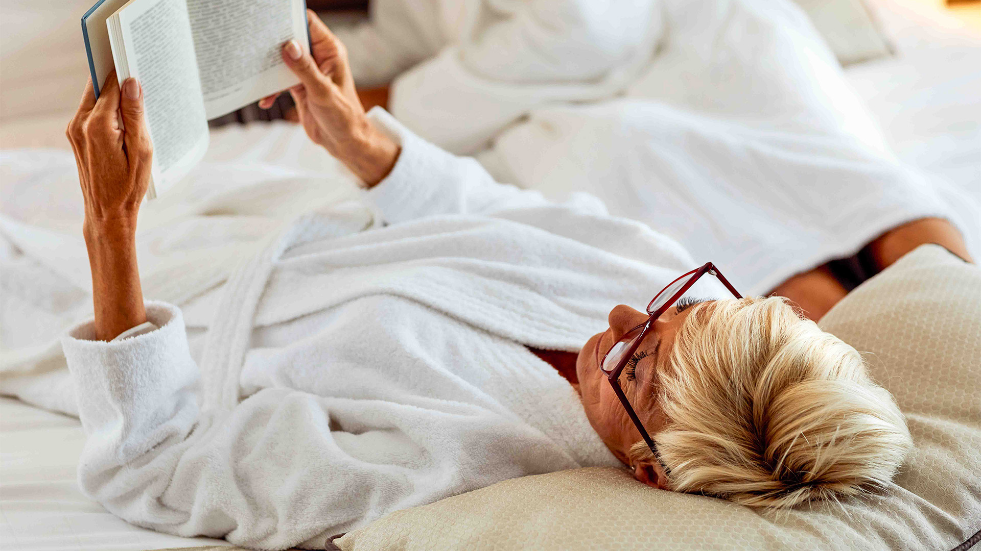 a woman lying down reading a book