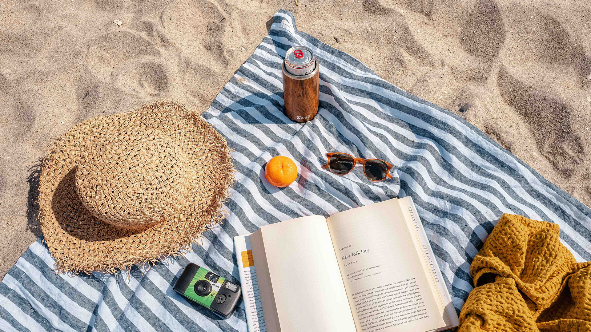 a blanket with a book and a hat on it