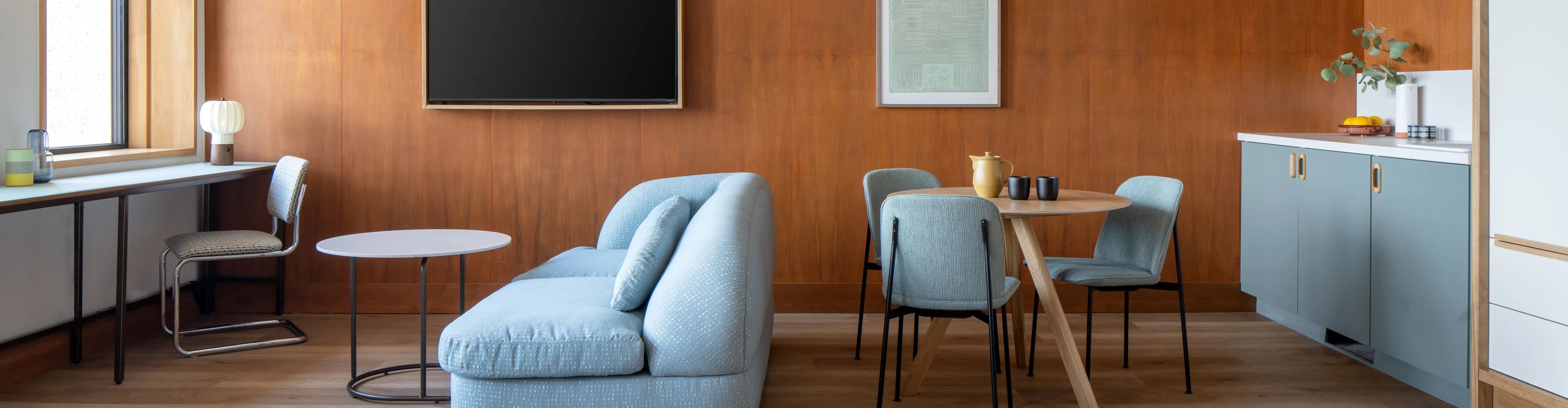 a room with a blue couch and chairs