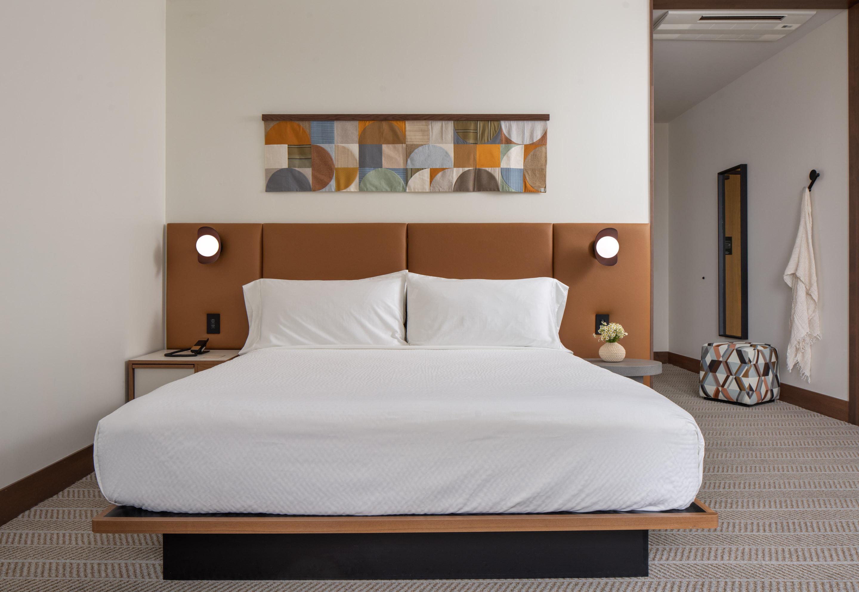a bed with white sheets and a brown headboard