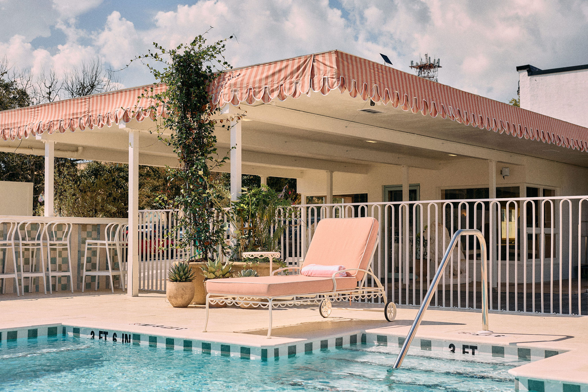 a pool with a pink chair and a white fence