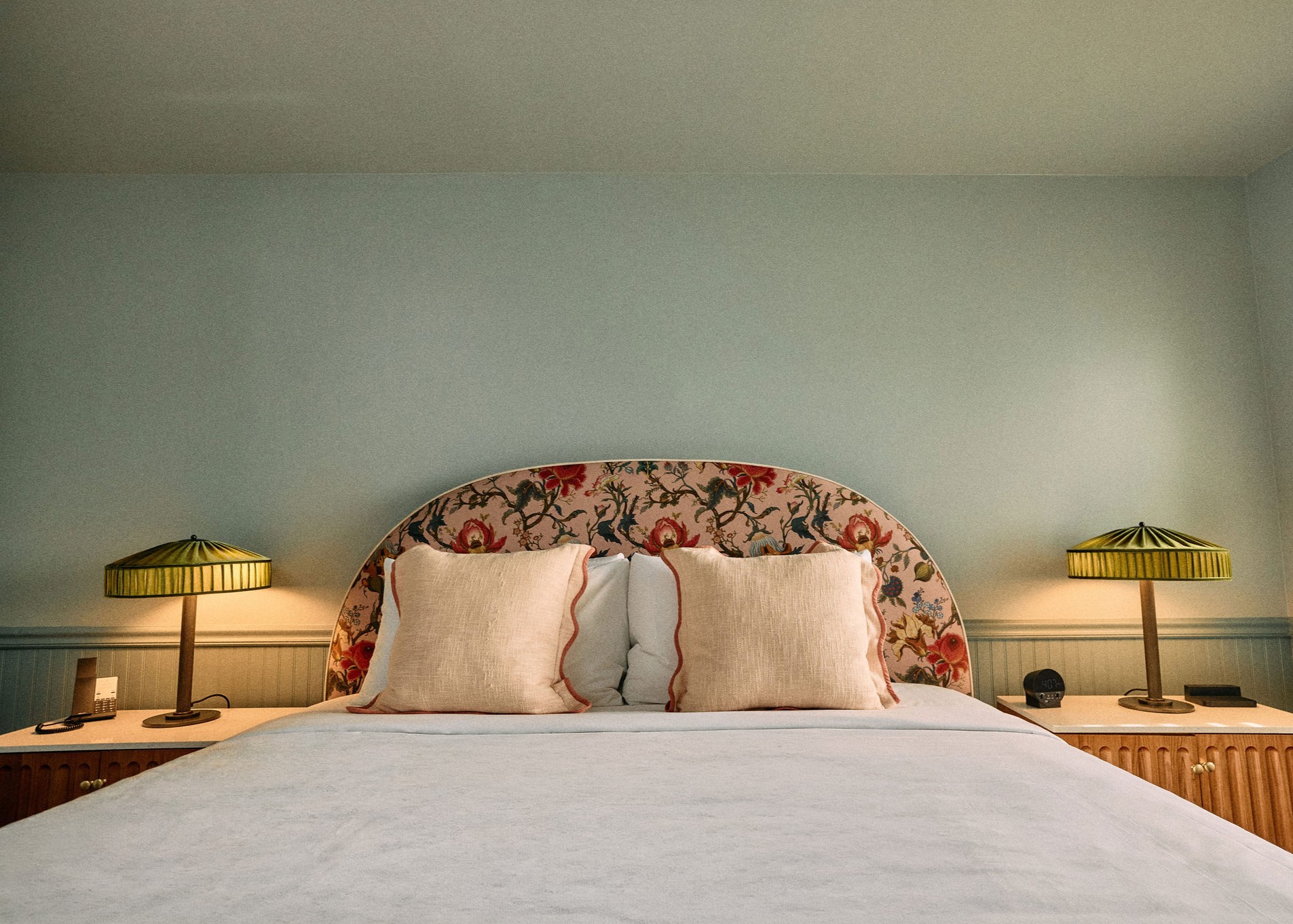 a bed with pillows and a lamp on the side