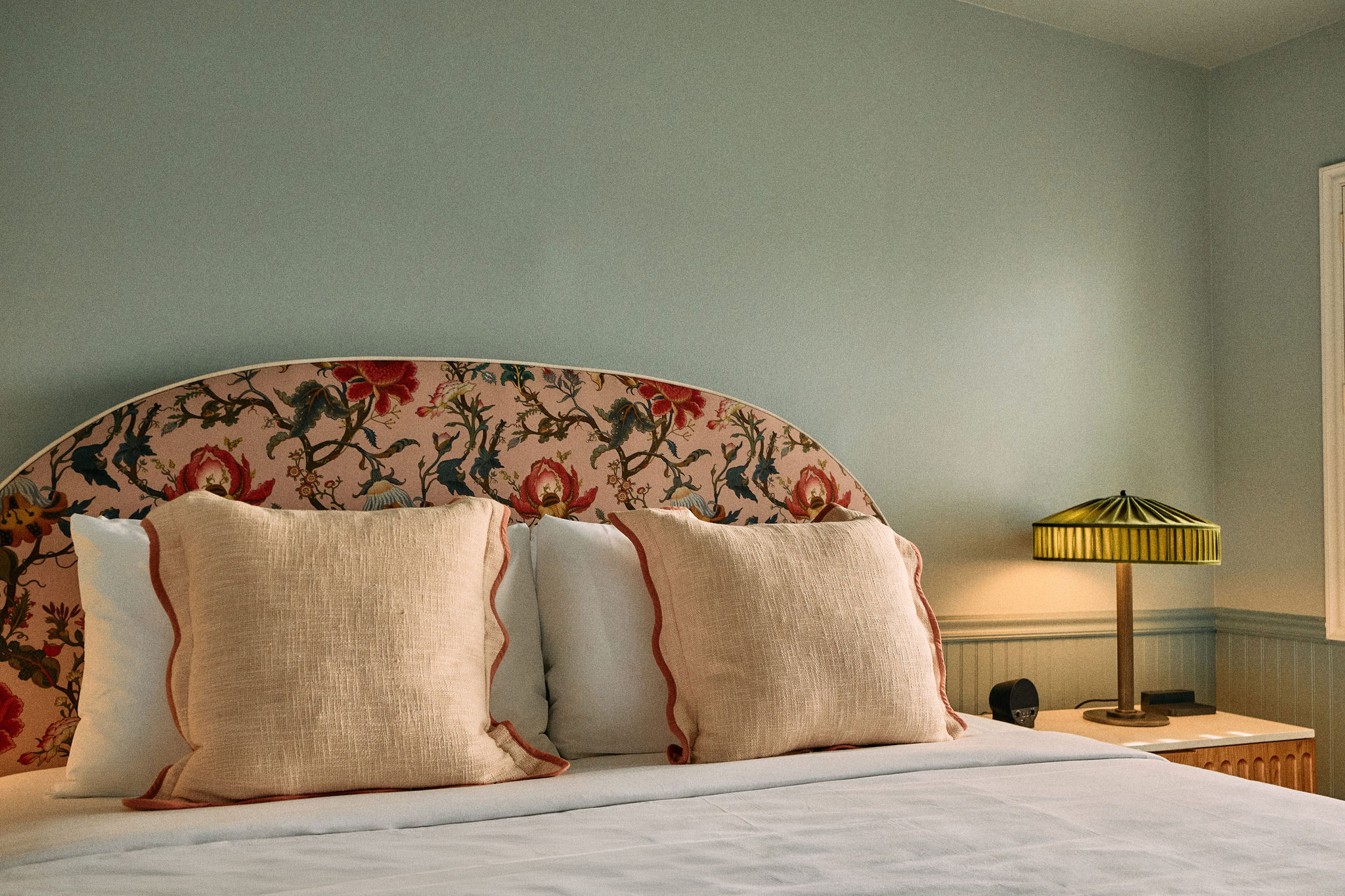 a bed with pillows and a lamp
