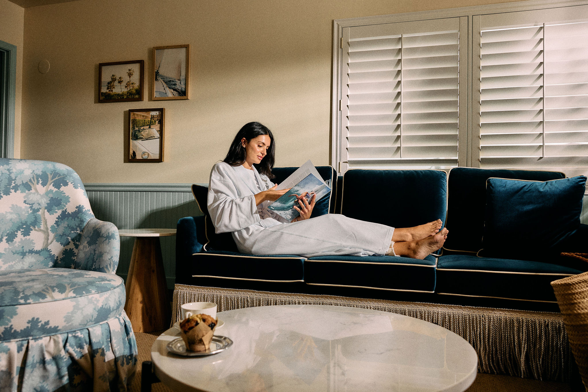 a woman reading a magazine on a couch