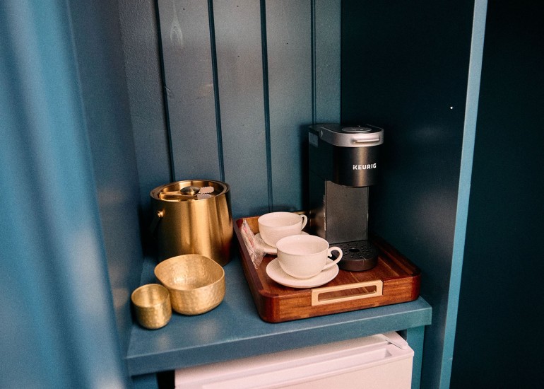 a small kitchen with a coffee maker and cups