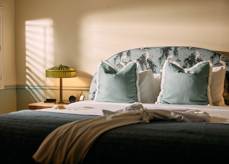 a bed with pillows and a lamp