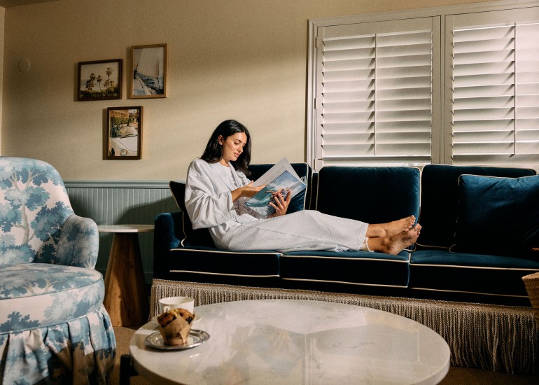 a woman reading a magazine on a couch