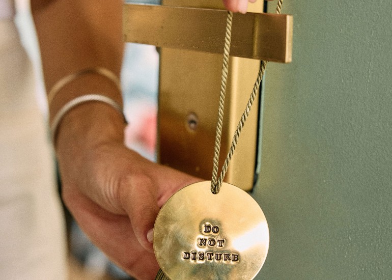 a person holding a gold coin with a tassel
